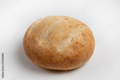 Round loaf of wheat bread on sourdough on a light background