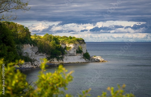 View of the cliffs covered with green vegetation against the blue sea and cloudy sky. Stevns Klint. photo