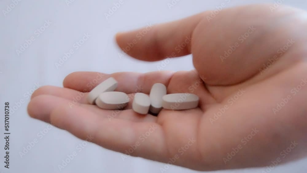 Hand holding pile of pills. Concept of medical drugs, pharmaceuticals Hand holding pile of pills. Concept of medical drugs, pharmaceuticals