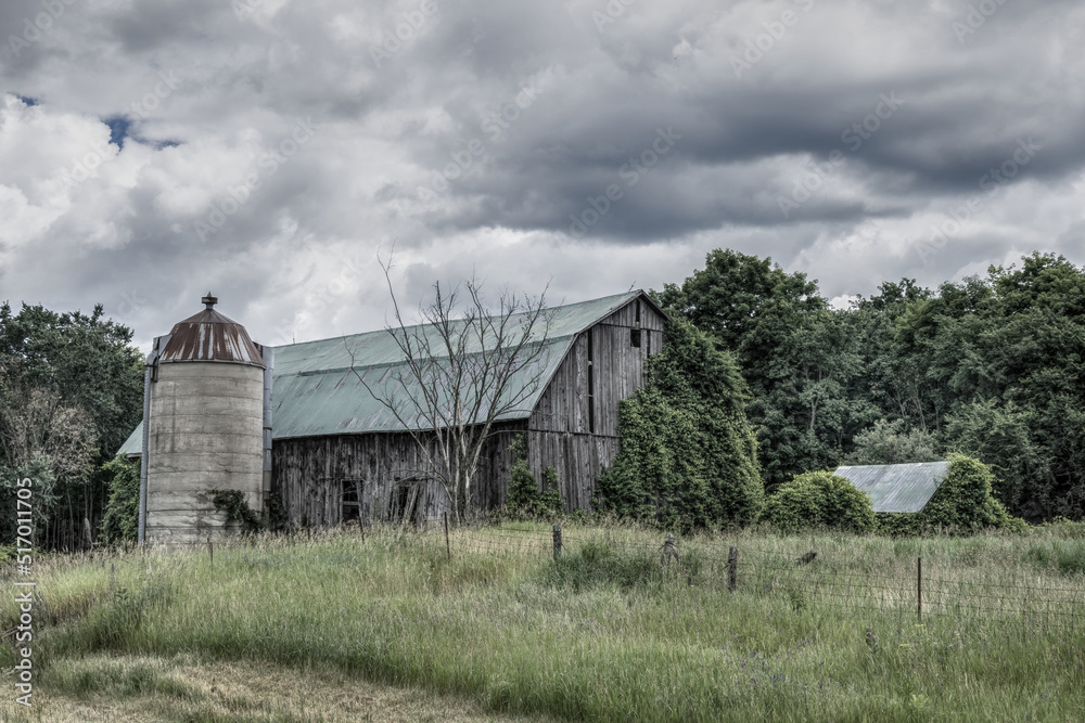Old dilapidated wooden barn in a farm field