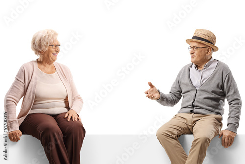 Senior man and woman sitting on a panel and having a conversation