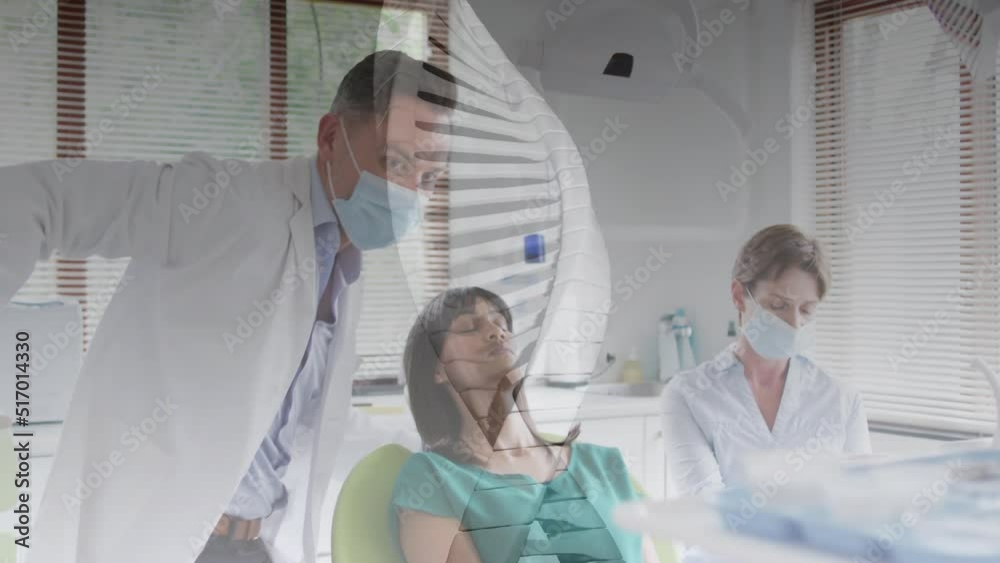 Animation of dna over caucasian doctors in face masks and female patient Animation of dna over caucasian doctors in face masks and female patient