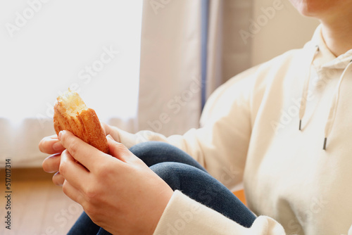 床に座ってパンを食べる女性 photo
