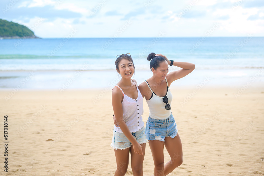 Two attractive women friends enjoying and relaxing on the beach,  Summer, vacation, holidays, Lifestyles concept.