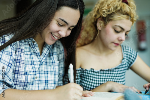 Young diverse students learning together inside university library