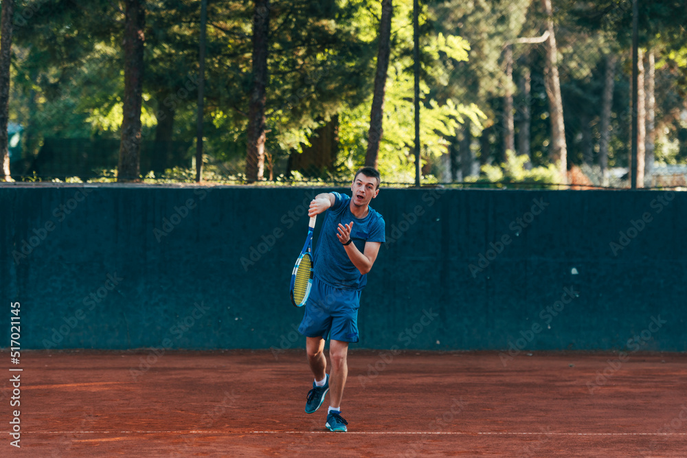 Obraz premium A professional tennis player is serving ball on a clay tennis court