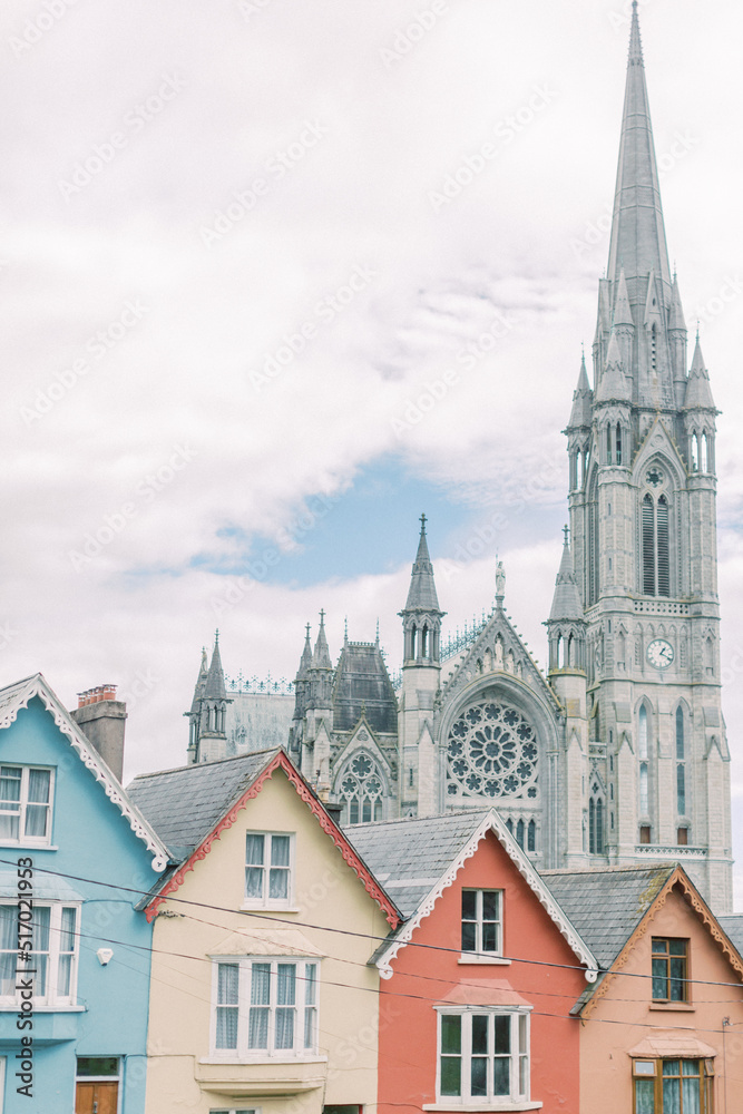 Row of colorful homes in front of cathedral in Cobh, Ireland