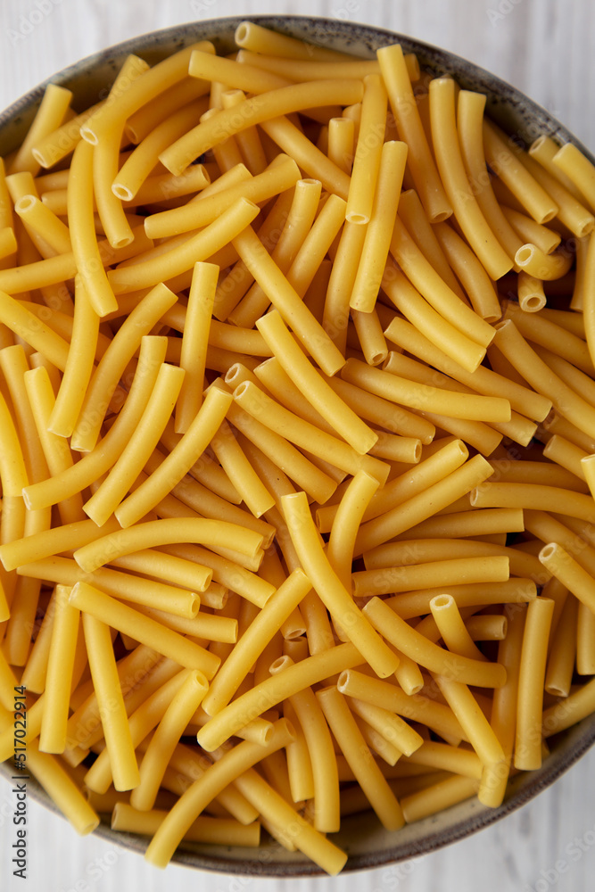 Dry Organic Maccheroni Pasta in a Bowl, top view. Flat lay, overhead, from above. Close-up. Dry Organic Maccheroni Pasta in a Bowl, top view. Flat lay, overhead, from above. Close-up.