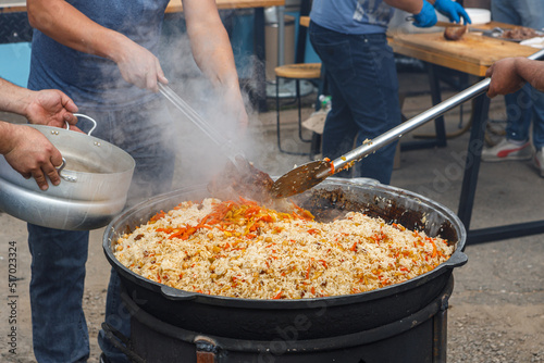 Stirring the pilaf in a large bowl during cooking outdoors.