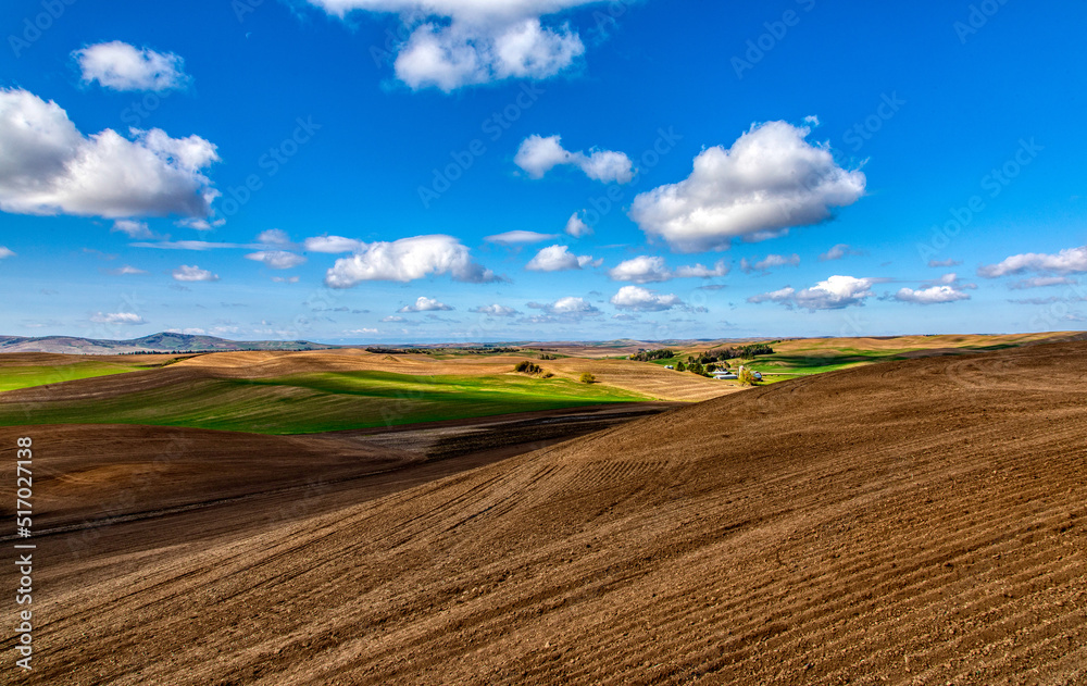 Farm in the distance among rolling hills Farm in the distance among rolling hills