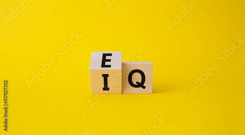 IQ or EQ symbol. Turned cube with words IQ, intelligence quotient to EQ, emotional quotient. Beautiful yellow background. Emotional and intelligence quotient concept. Copy space.