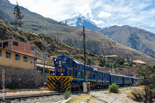 Blue train driving through the railways of the Urubamba Sacred muntain valley in peru photo