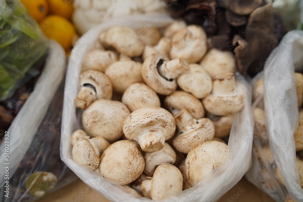 Champignon Mushroom or Jamur Kancing in plastic at traditional market. Selective focus Champignon Mushroom or Jamur Kancing in plastic at traditional market. Selective focus