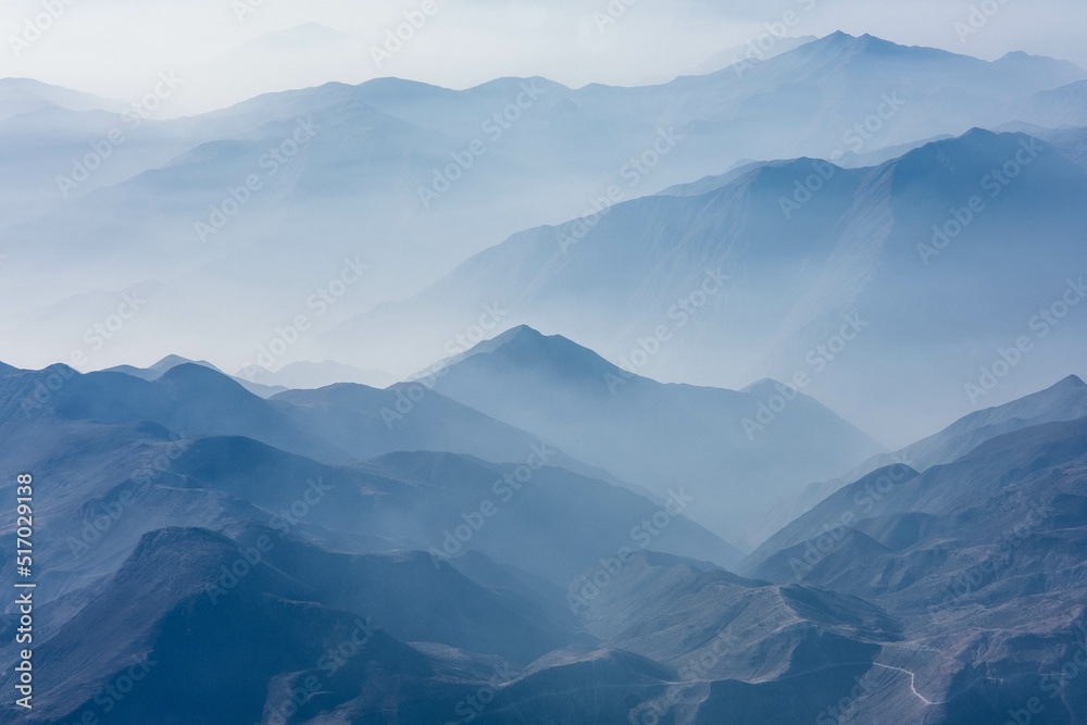 The hazy Peruvian Andes Mountains seen from above in an airplane view The hazy Peruvian Andes Mountains seen from above in an airplane view