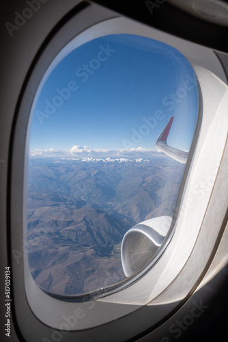 The hazy Peruvian Andes Mountains seen from above in an airplane view