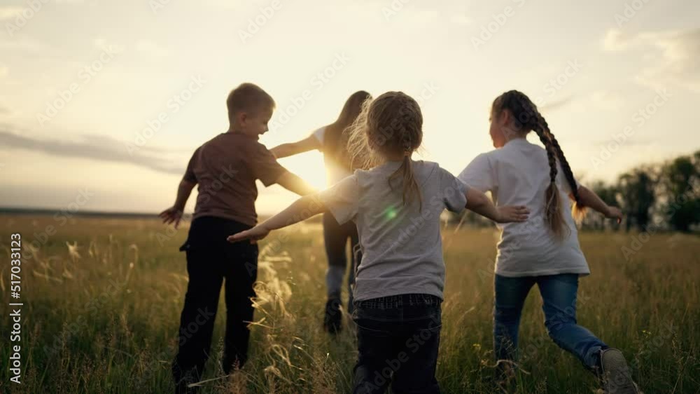 Happy family.Group of children run across grass in park together at sunset.Boy and girls outdoors in meadow.Child run across the field in park.Kids are play in park.Dream desire to win.Success concept Happy family.Group of children run across grass in park together at sunset.Boy and girls outdoors in meadow.Child run across the field in park.Kids are play in park.Dream desire to win.Success concept