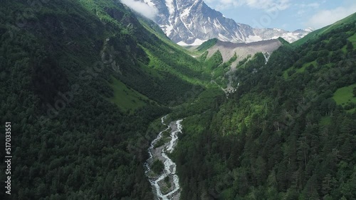 Aerial of curving Baksan river and Cheget mountain, North Caucasus. Picturesque snow capped peaks of Donguz Orun-Cheget-Karabashi in Elbrus region. Breathtaking summer landscape photo