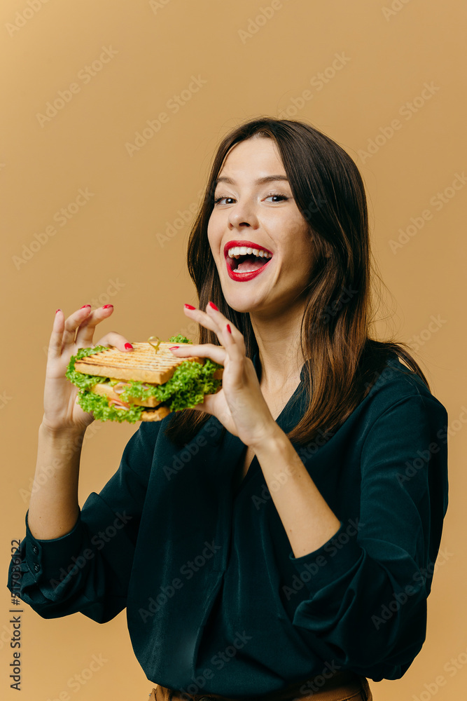 Beautiful young woman posing with a sandwich on a colored background.. Beautiful young woman posing with a sandwich on a colored background..