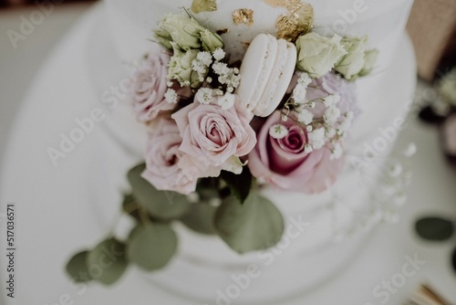 High-angle view of a white wedding cake with flowers and fancy decoration photo