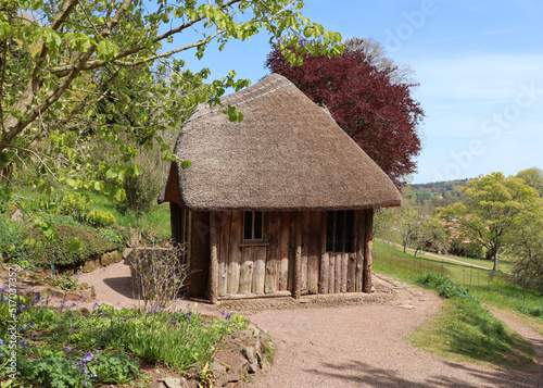 Принти на полотні An quaint hut with a thatched roof looks out over the English countryside