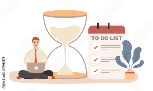 Work time activity strategy. Man sitting on floor and working with laptop near big hourglass and to do list. Employee planing