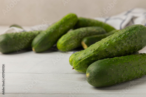 Fresh cucumbers on white texture wood. Vegetarian organic vegetables.Ingredient for salad. Healthy food.Copy space.Place for text