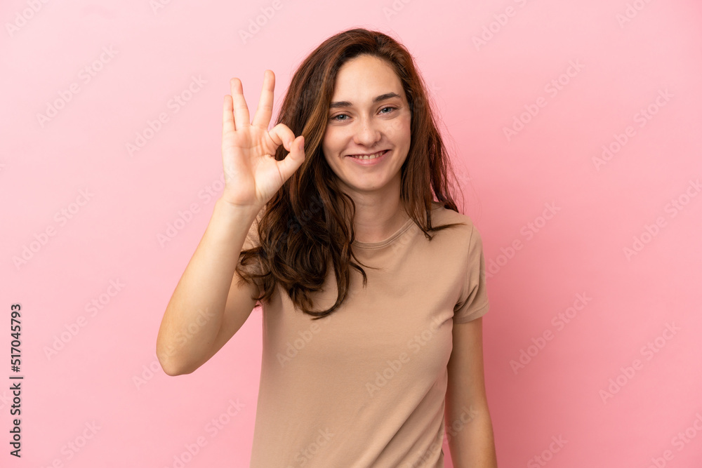 Young caucasian woman isolated on pink background showing ok sign with fingers Young caucasian woman isolated on pink background showing ok sign with fingers
