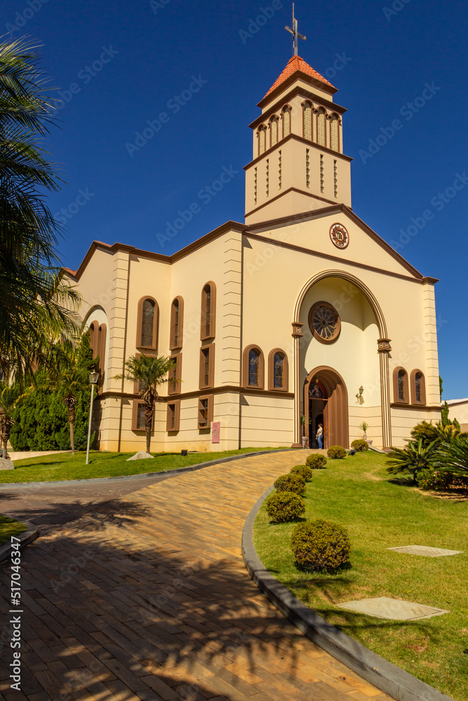 Vista lateral da Paróquia São Francisco de Assis - Diocese de Anápolis em Goiás em um dia claro com o céu azul ao fundo.