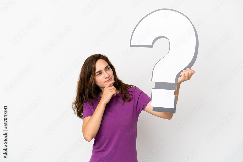 Young caucasian woman isolated on white background holding a question mark icon and having doubts