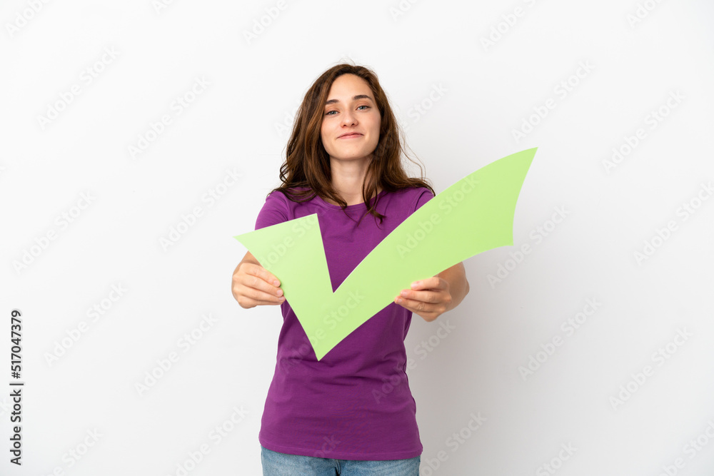Young caucasian woman isolated on white background holding a check icon with happy expression Young caucasian woman isolated on white background holding a check icon with happy expression