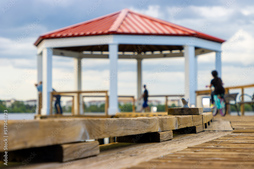People relax under gazebo on lake People relax under gazebo on lake