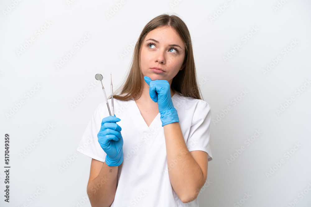 Dentist woman holding tools isolated on white background and looking up Dentist woman holding tools isolated on white background and looking up