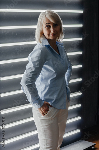 a woman in a blue shirt near a wall with backlight © Владимир Паляница