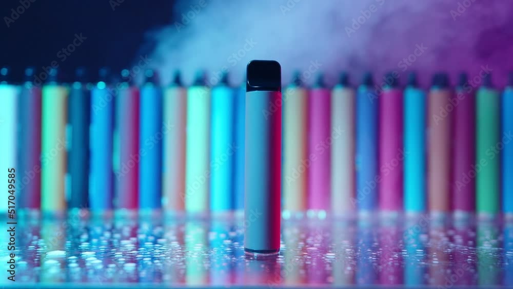 Lots of E-Cigarettes and Vapes with Smoke in Neon Lighting. Concept of Bad Habits. Modern Smoking Electronic Cigarettes. Slow Motion Lots of E-Cigarettes and Vapes with Smoke in Neon Lighting. Concept of Bad Habits. Modern Smoking Electronic Cigarettes. Slow Motion