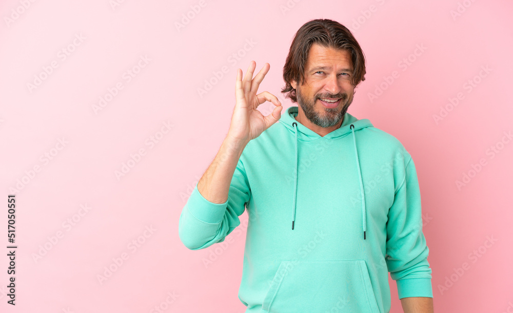 Senior dutch man isolated on pink background showing ok sign with fingers Senior dutch man isolated on pink background showing ok sign with fingers