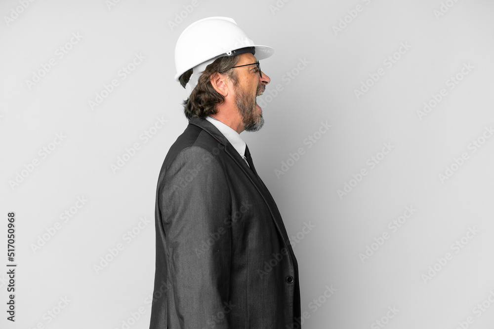 Young architect man with helmet over isolated background laughing in lateral position