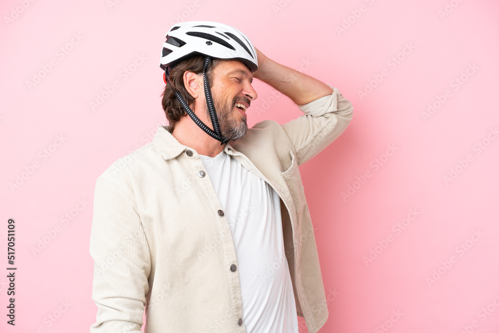 Senior dutch man with bike helmet isolated on pink background has realized something and intending the solution