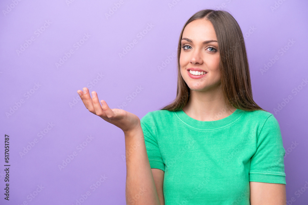 Young caucasian woman isolated on purple background extending hands to the side for inviting to come Young caucasian woman isolated on purple background extending hands to the side for inviting to come