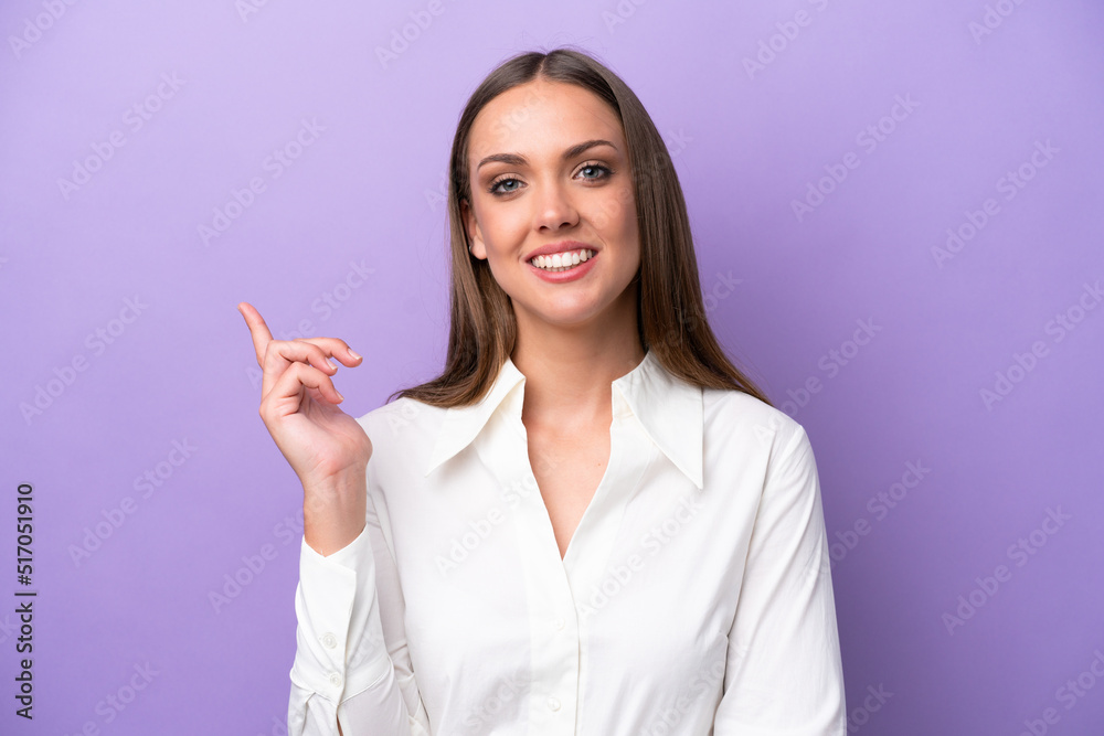 Young caucasian woman isolated on purple background happy and pointing up Young caucasian woman isolated on purple background happy and pointing up