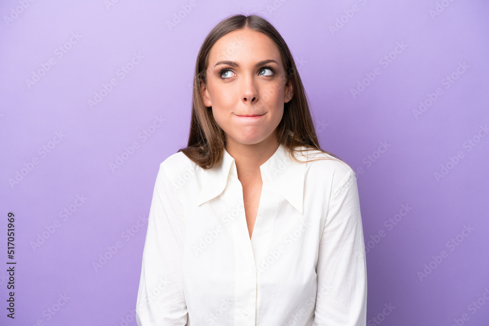 Young caucasian woman isolated on purple background having doubts while looking up