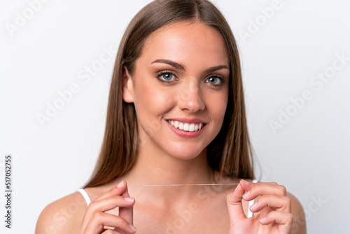 Young caucasian woman isolated on white background with dental floss. Close up portrait