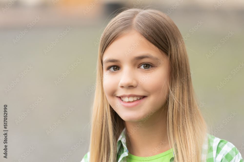 Portrait of happy teen girl with smiling face blurry outdoors, copy space Portrait of happy teen girl with smiling face blurry outdoors, copy space