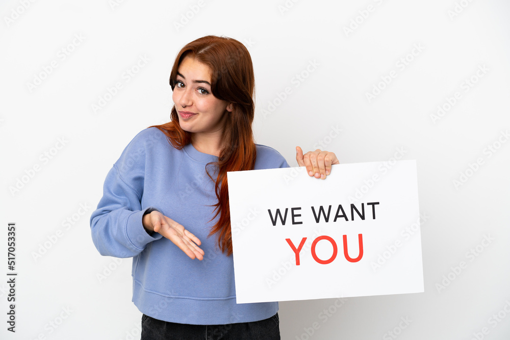 Young redhead woman isolated on white background holding We Want You board and pointing it Young redhead woman isolated on white background holding We Want You board and pointing it