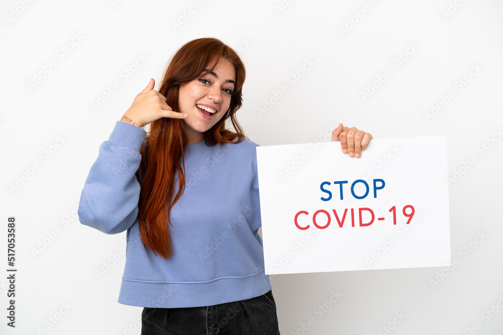 Young redhead woman isolated on white background holding a placard with text Stop Covid 19 and doing phone gesture Young redhead woman isolated on white background holding a placard with text Stop Covid 19 and doing phone gesture