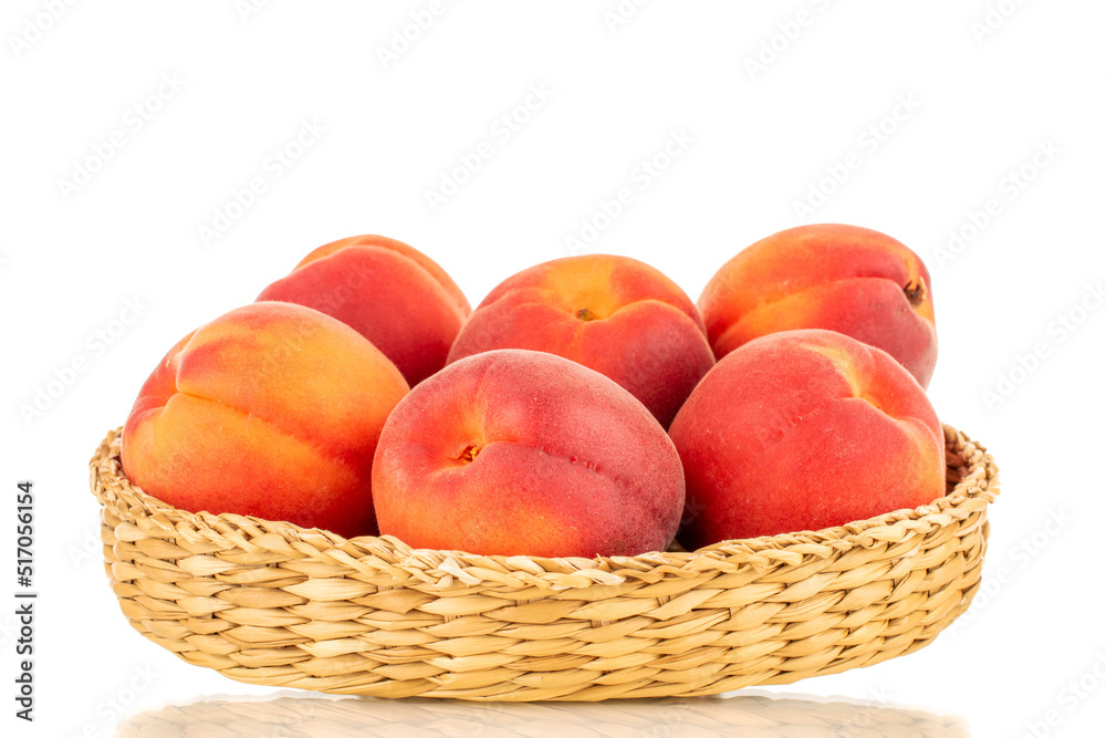 Several ripe red apricots on a straw plate, close-up, isolated on a white background. Several ripe red apricots on a straw plate, close-up, isolated on a white background.