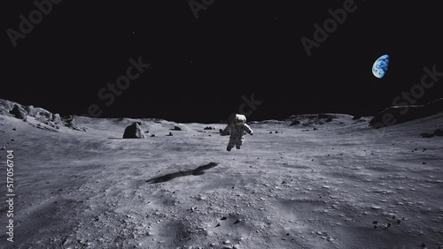 Spaceman alone on the moon in view of the earth.slowly approaching the front screen photo