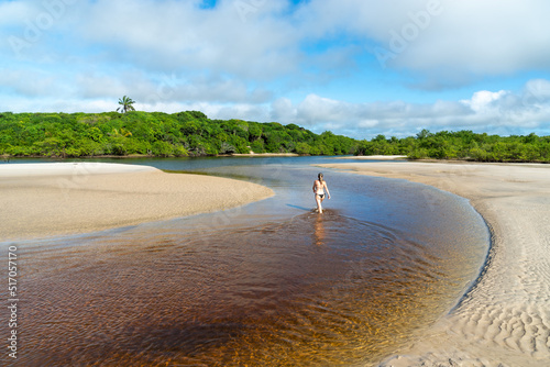 Young beautiful woman walking inside the reddish water. photo