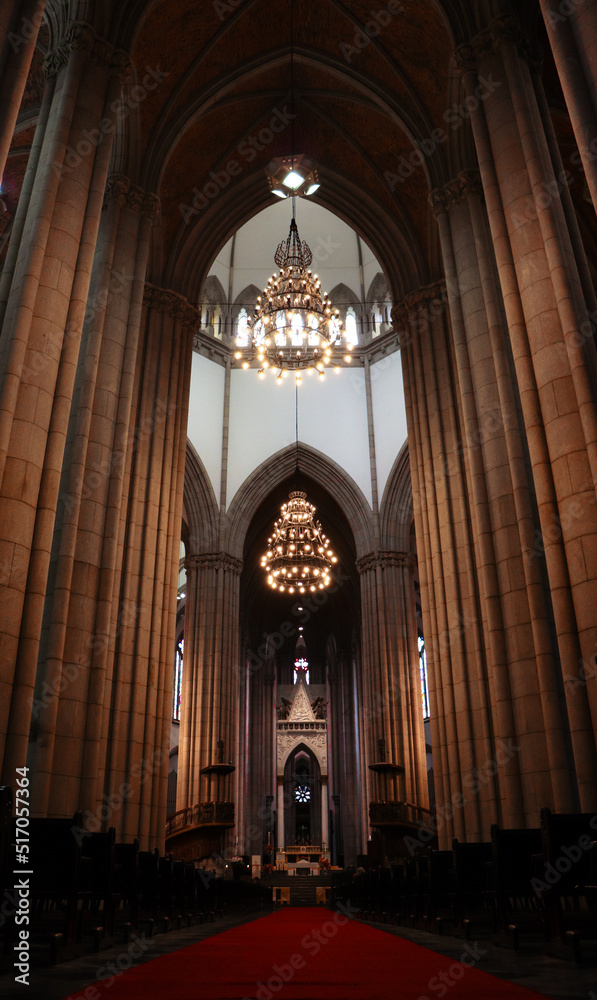 Obraz premium Interior da catedral mostra sua arquitetura gótica católica em antiga construção com pilares, lustres e altar