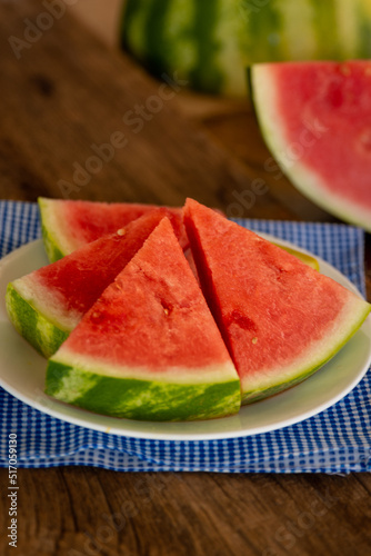 a plate of fresh watermelon with a blue napkin
