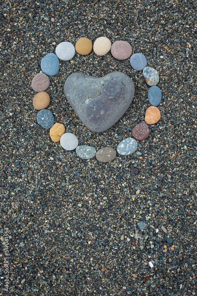 Heart shaped sea stone pebble on sandy beach Heart shaped sea stone pebble on sandy beach